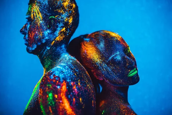 As pessoas são pó fluorescente colorido. um par de amantes dançando em uma discoteca . — Fotografia de Stock