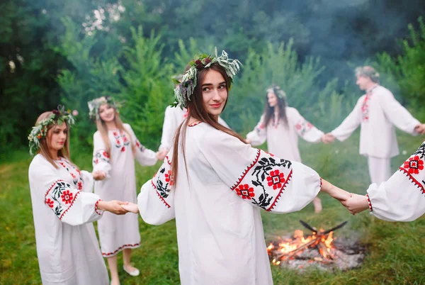 No meio do verão. Jovens em roupas eslavas giram em torno de um incêndio no verão — Fotografia de Stock