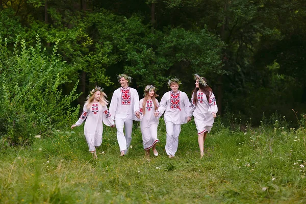 Midsommar. Människor som springer i naturen i slaviska kläder. — Stockfoto