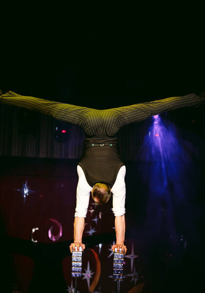 Acrobat performs a difficult trick in the circus.