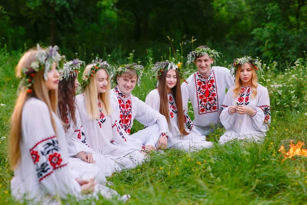 Hochsommer. Eine Gruppe junger Menschen slawischen Aussehens sitzt am Lagerfeuer. — Stockfoto