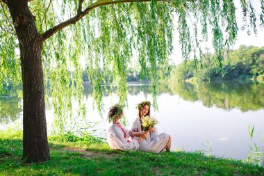 Midsummer. Gölün kıyısında Slav kostümleri genç seven çift. Ivan Kupala Slav tatili.