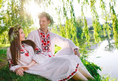 Midsummer. Gölün kıyısında Slav kostümleri genç seven çift. Ivan Kupala Slav tatili.