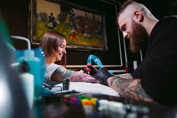 Artista de tatuagem profissional faz uma tatuagem em uma mão de meninas. — Fotografia de Stock