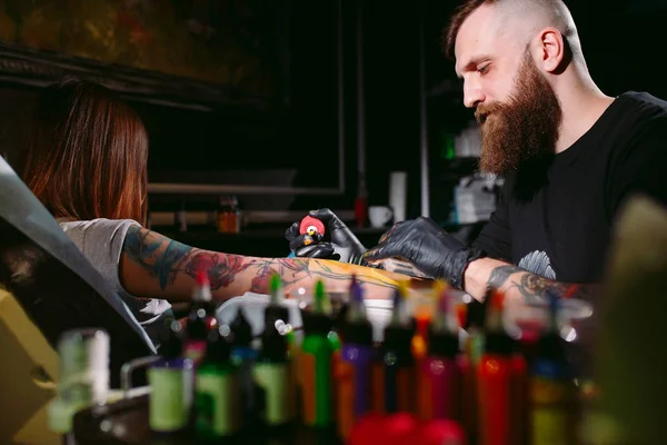 Professional tattoo artist makes a tattoo on a young girls hand. — Stock Photo, Image