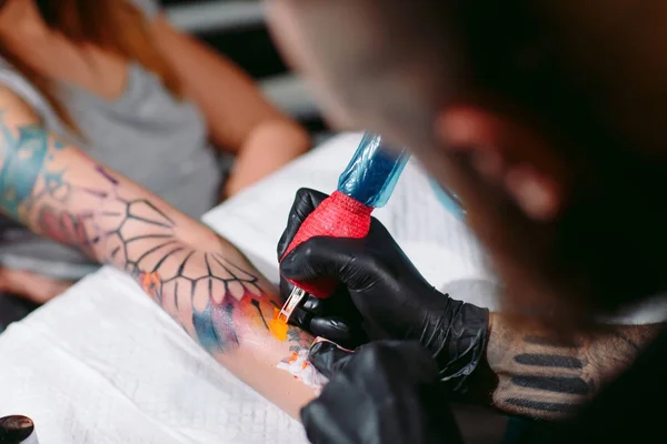 Tatuaggio artista professionista fa un tatuaggio su una mano di giovani ragazze. — Foto Stock
