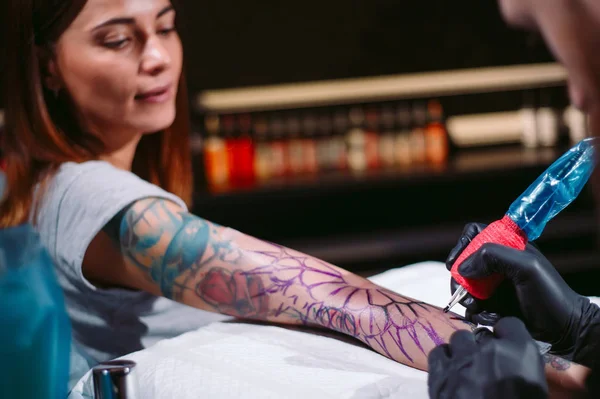 Artista de tatuagem profissional faz uma tatuagem em uma mão de meninas. — Fotografia de Stock