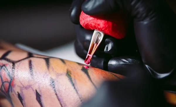 Professional tattoo artist makes a tattoo on a young girls hand. — Stock Photo, Image