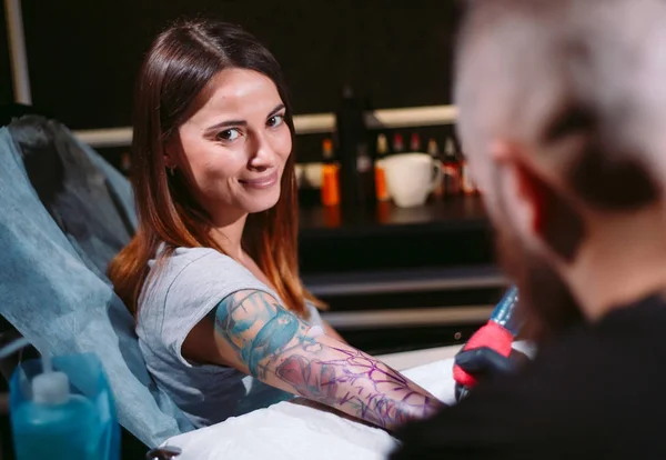Artista profesional del tatuaje hace un tatuaje en una mano de chicas jóvenes. — Foto de Stock