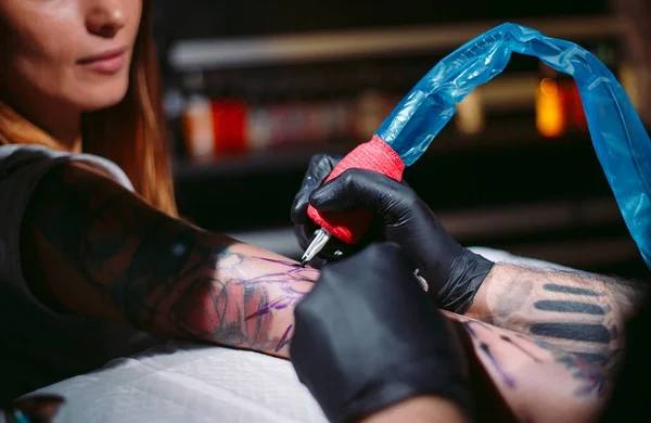Artista de tatuagem profissional faz uma tatuagem em uma mão de meninas. — Fotografia de Stock