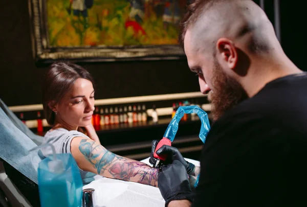 Professional tattoo artist makes a tattoo on a young girls hand. — Stock Photo, Image