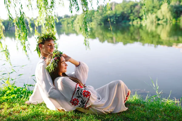 Сон літню. Молода любляча пара в слов'янських костюмах на березі озера. Слов'янське свято Івана Купала. — стокове фото
