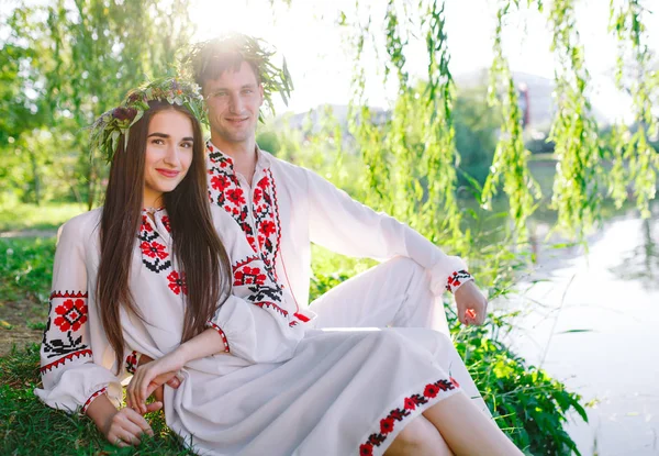 Hochsommer. junges Liebespaar in slawischen Kostümen am Ufer des Sees. slawischer Feiertag von ivan kupala. — Stockfoto