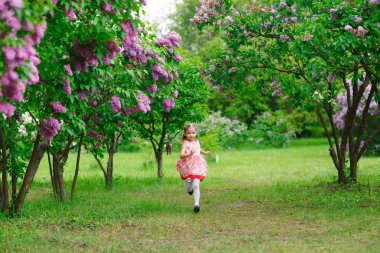 Küçük bir kız parkta dışarıda koşuyor..