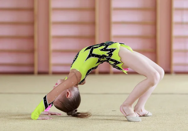 Ung flicka gör gymnastik i gymmet. — Stockfoto