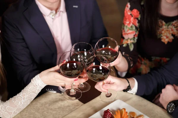 Amigos en un restaurante bebiendo vino tinto . —  Fotos de Stock