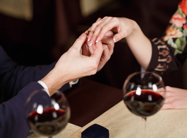 Young Man puts the ring on the finger of his girlfriend