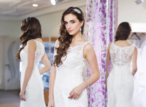 Frau probiert Hochzeitskleid im Geschäft an. — Stockfoto