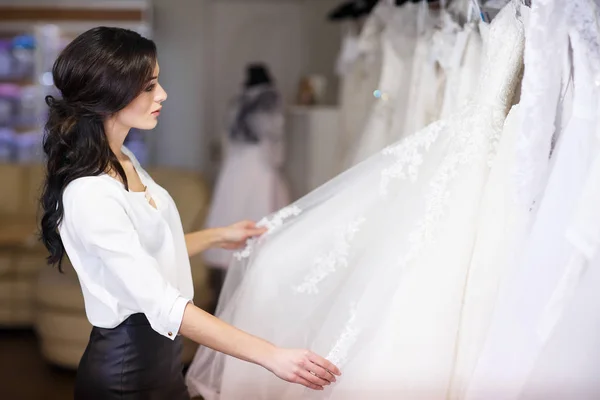 Händlerberater im Hintergrund von Brautkleidern — Stockfoto