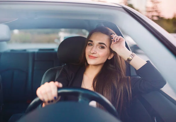 Linda chica morena en el coche. Elegante mujer de negocios conduciendo un coche . — Foto de Stock