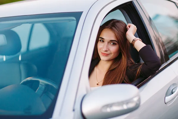 Ragazza bruna carina in macchina. Elegante donna d'affari alla guida di una macchina . — Foto Stock