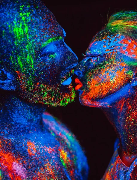 Retrato de un par de amantes pintados en polvo fluorescente . — Foto de Stock