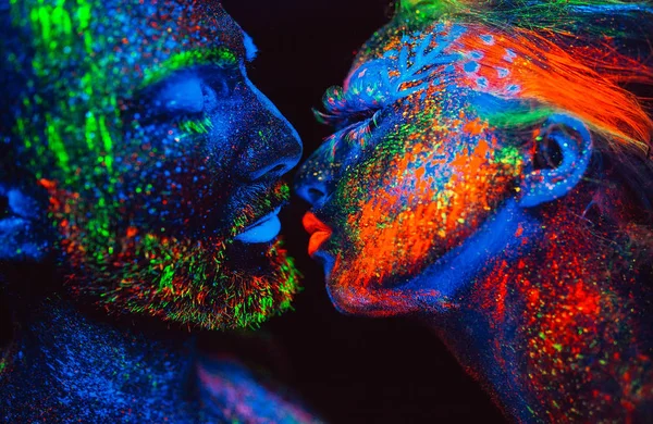 Portrait of a pair of lovers painted in fluorescent powder. — Stock Photo, Image