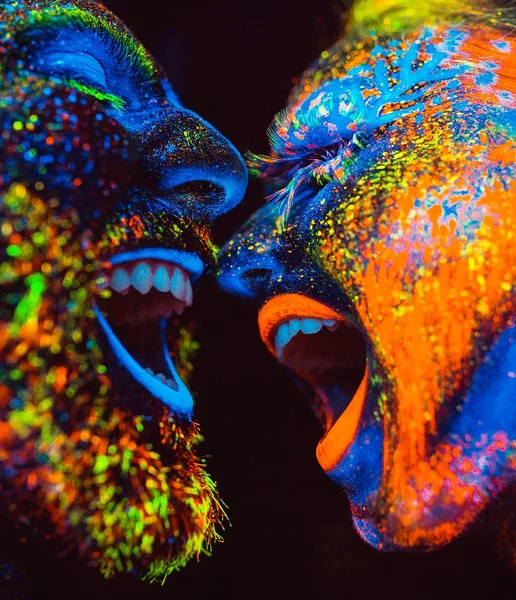 Conceito. Um casal a sorrir. Retrato de um par de amantes pintados em pó fluorescente . — Fotografia de Stock