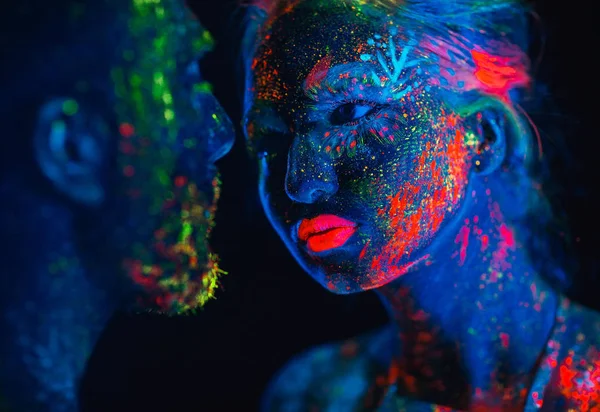 Retrato de um par de amantes pintados em pó fluorescente — Fotografia de Stock