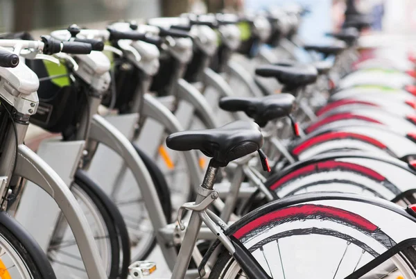 Row of parked vintage bicycles bikes for rent on sidewalk — Stock Photo, Image