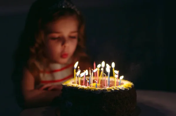 Geburtstag. ein kleines süßes Mädchen bläst Kerzen auf dem Herd aus — Stockfoto