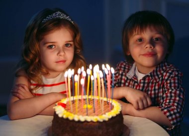 Çocuk doğum günü. Çocuklar bir doğum günü pastası mumlar ile yakın.