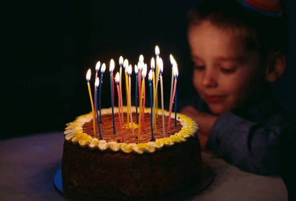 Geburtstag. Ein kleiner Junge bläst Kerzen auf dem Herd aus. — Stockfoto
