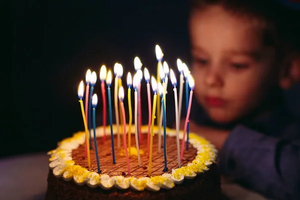 Anniversaire. Un petit garçon souffle des bougies sur la cuisinière . — Photo