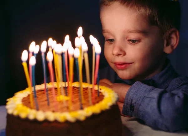 Birthday. A little boy blows out candles on the stoke. — Stock Photo, Image