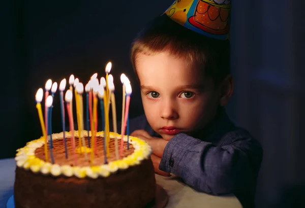 Geburtstag. Ein kleiner Junge bläst Kerzen auf dem Herd aus. — Stockfoto