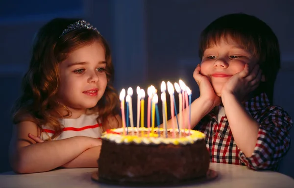 Anniversaire des enfants. Enfants près d'un gâteau d'anniversaire avec des bougies . — Photo