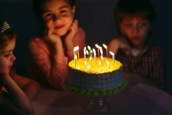 Kindergeburtstag. Kinder neben einer Geburtstagstorte mit Kerzen — Stockfoto