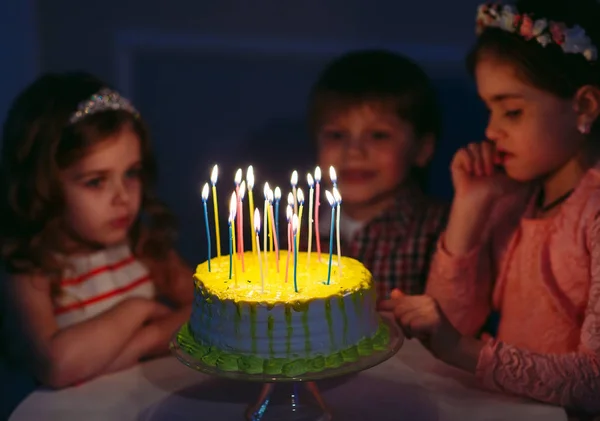 Childrens birthday. Children near a birthday cake with candles — Stock Photo, Image
