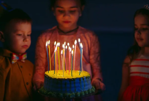 Kindergeburtstag. Kinder neben einer Geburtstagstorte mit Kerzen — Stockfoto