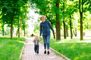 Yaz parkında yürüyen anne ve oğlu.