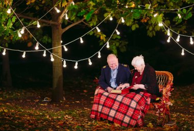 Mutlu anılar. Mutlu yaşlı çift fotoğraf ile albüm izlerken kanepede oturan