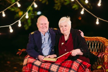 Mutlu anılar. Mutlu yaşlı çift fotoğraf ile albüm izlerken kanepede oturan