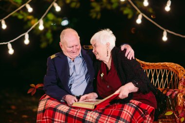 Mutlu anılar. Mutlu yaşlı çift fotoğraf ile albüm izlerken kanepede oturan