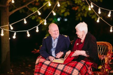 Mutlu anılar. Mutlu yaşlı çift fotoğraf ile albüm izlerken kanepede oturan