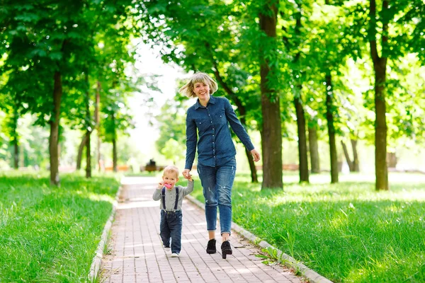 Yaz parkında yürüyen anne ve oğlu.