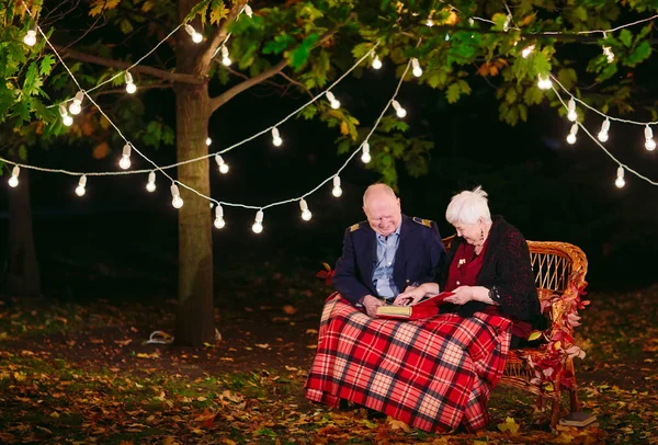 Mutlu anılar. Mutlu yaşlı çift fotoğraf ile albüm izlerken kanepede oturan