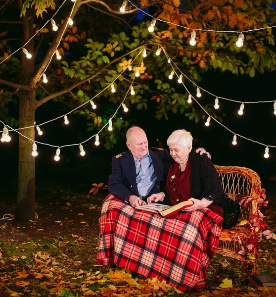 Mutlu anılar. Mutlu yaşlı çift fotoğraf ile albüm izlerken kanepede oturan