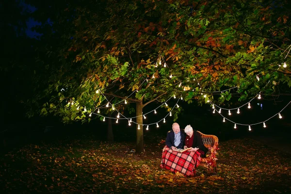 Mutlu anılar. Mutlu yaşlı çift fotoğraf ile albüm izlerken kanepede oturan