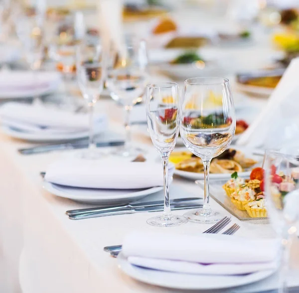 Mesa muy bien servida en un restaurante sobre un mantel blanco — Foto de Stock